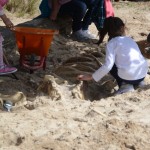 Kids uncovering a skeleton in the sand